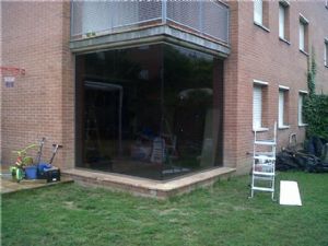 Cerramiento de la terraza con vidrio laminado para ampliar el salón en una casa en Granollers..