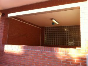 Cubrir hueco en la fachada de una escuela del Vallès con carpintería de aluminio blanco.