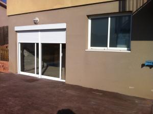 Balconera de aluminio, con vídrio cámara y con persiana para acceder a vivienda.