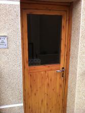 Fabricación de puerta en aluminio imitación madera con nudo para vivienda en Montmeló.