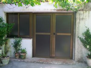 En casa de campo de Vilanova del Vallès Barcelona, instalación de ventana y puerta de aluminio con cristal oscuro.