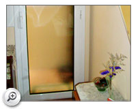 Instalación de puerta practicable en aluminio blanco cristal con cámara para galería en piso de Barcelona.
